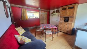 a living room with a red couch and a table at Mutzgraben Lodge in Seeberg