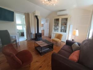a living room with a couch and a wood stove at Le Cottage in Marçon
