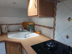 a small kitchen with a sink and a stove at Le Cottage in Marçon +35 photos