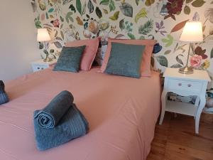a bedroom with a pink bed with two tables and two lamps at Le Cottage in Marçon