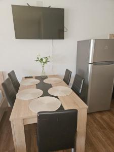 a table with chairs and a refrigerator in a room at Wonder home in Sutomore