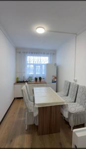 a kitchen with a table and chairs in a room at Janai Guest house in Karakol