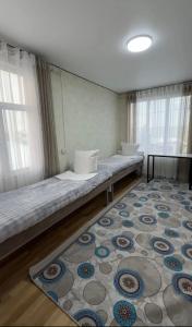 a room with a long bed with a rug at Janai Guest house in Karakol