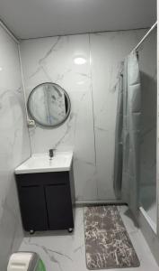 a bathroom with a sink and a mirror and a shower at Janai Guest house in Karakol +5 photos