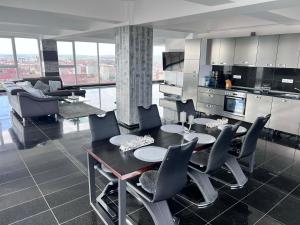a kitchen and dining room with a table and chairs at Rania Penthouse 2 in Şelimbăr