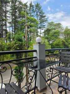 a balcony with a table and chairs and trees at French Hotel in Kobuleti