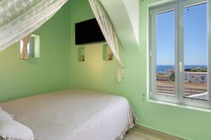 a bedroom with a bed and a large window at Villa Fotis in Ano Syros