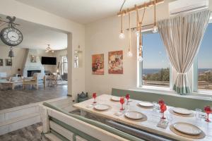 a dining room with a table and a large window at Villa Fotis in Ano Syros