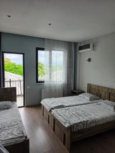 a bedroom with two beds and a large window at French Hotel in Kobuleti