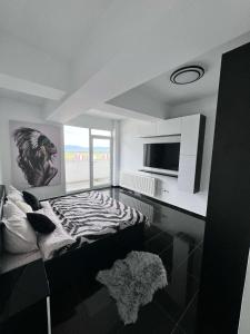 a zebra themed room with a bed and a television at Rania Penthouse 2 in Şelimbăr
