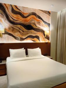 a bedroom with a bed and a painting on the wall at Krishna Palace Hotel , Ulhasnagar in Ulhāsnagar