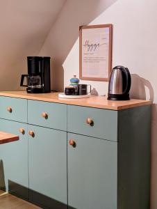 a dresser with a coffee maker on top of it at HyggeHome Strandelhjørn in Vojens