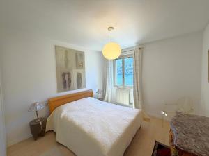 a bedroom with a white bed and a window at Cristoforis Lake View House in Carate Urio