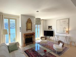 a living room with a couch and a fireplace at Cristoforis Lake View House in Carate Urio