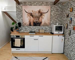 a kitchen with a painting of a bull on the wall at HyggeHome Strandelhjørn in Vojens