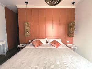 a bedroom with a large bed with two orange pillows at Dimora Coloré in Nereto +58 photos