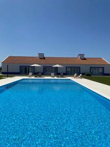 a swimming pool in front of a house at Serras d'Sal in Alcochete