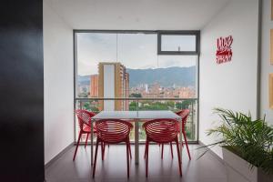a table and chairs in a room with a large window at Hotel Piso 12 in Bello