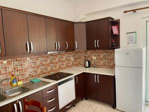 a kitchen with brown cabinets and a white refrigerator at Dimora Seaside Apartments in Ksamil