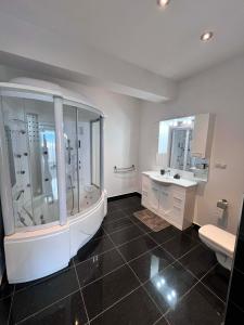 a large bathroom with a tub and a sink at Rania Penthouse 2 in Şelimbăr