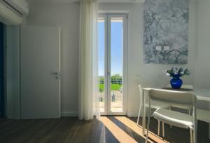 a dining room with a table and chairs and a sliding glass door at Dimora Coloré in Nereto
