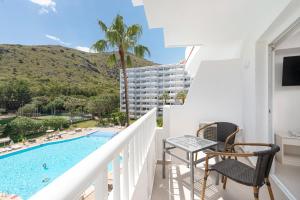 a balcony with a view of the pool and the mountains at Apartamentos Siesta I in Port d'Alcudia