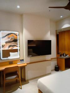 a bedroom with a bed and a television on a wall at Krishna Palace Hotel , Ulhasnagar in Ulhāsnagar