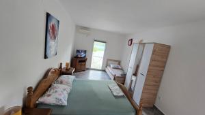 a bedroom with a bed and a refrigerator in it at Xigga apartments in Donji Stoliv