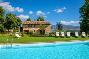 a house with a swimming pool in front of a building at Casale Donatelli in Radicofani