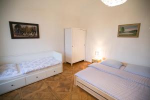 a bedroom with two beds and a cabinet at Heldův pokojík v centru města in Zákupy