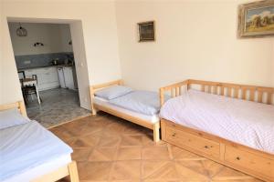a room with two twin beds and a kitchen at Heldův pokojík v centru města in Zákupy