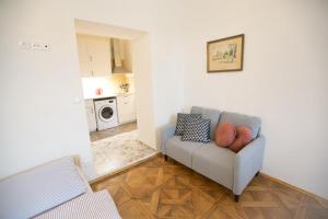 a living room with a couch and a kitchen at Heldův pokojík v centru města in Zákupy