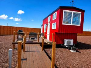 a red tiny house with a wooden deck at Zion Couples Retreat Romantic Desert Tiny Home in Apple Valley