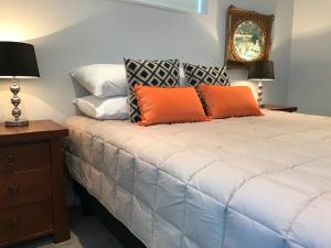 una camera da letto con un letto con cuscini arancioni sopra di Picton Waterfront Oxley's Luxury Apartment a Picton