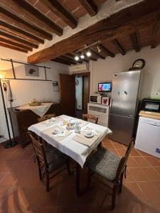 a kitchen with a table with chairs and a refrigerator at Casa Didi in Cetona