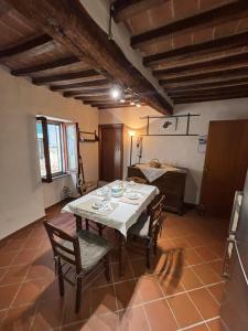 a dining room with a white table and chairs at Casa Didi in Cetona