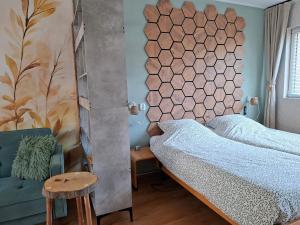 a bedroom with a bed and a chair at Sfeervolle Studio 't kapucijntje Ossendrecht, near Antwerp in Ossendrecht