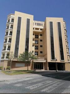 a large building with a tree in front of it at Spacious 2BR Apartment,3 Bathrooms, Near Mall in Abu Dhabi