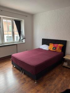 a bedroom with a bed with a purple bedspread at Marivel Wohnung in Freudenstadt