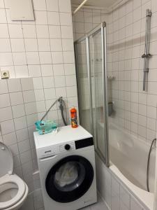 a washing machine in a bathroom with a toilet and a shower at Marivel Wohnung in Freudenstadt