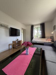 a living room with a vase of flowers on a rug at Skeppsdockans Vandrarhem in Söderköping