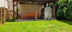 a wooden bench sitting under a gazebo in a yard at Chaloupka v srdci památkové zóny in Putím