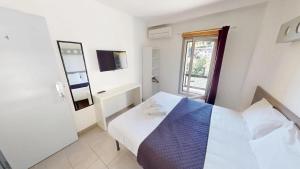 a white bedroom with a bed and a window at HÔTEL Relais de Monti in Menton