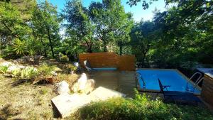 a swimming pool with a bench and a chair next to it at Entre Terrasses et Restanque - Pierrevert in Pierrevert
