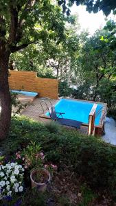 a pool with a bench and a chair next to it at Entre Terrasses et Restanque - Pierrevert in Pierrevert