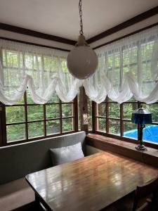 a dining room with a table and two windows at Guesthouse Lavande in Chino