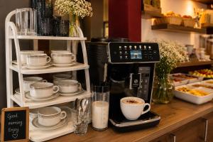 a counter with cups and a coffee maker on it at La Belle Heure B&B - formerly Huis van Steen - in Lelystad
