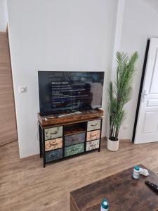 a flat screen tv on a stand in a living room at STUDIO COZY 20m2 in Les Attaques