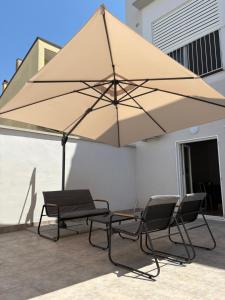 two chairs and a large umbrella on a patio at Il Canto Quinto in Acquaviva delle Fonti