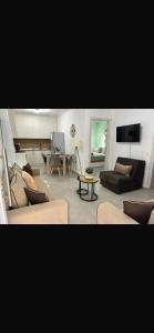 a living room with two couches and a tv at Soleil House Thassos in Kallirákhi